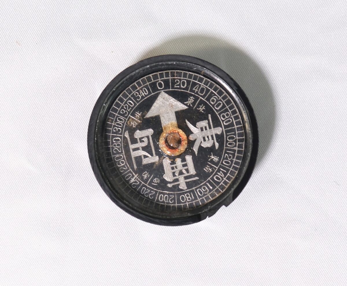 reverse compass, often characterized by having east and west reversed compared to standard compasses.It typically features a black face with Kanji characters indicating cardinal directions, with reverse compass, often characterized by having east and west reversed compared to standard compasses.It typically features a black face with Kanji characters indicating cardinal directions, with