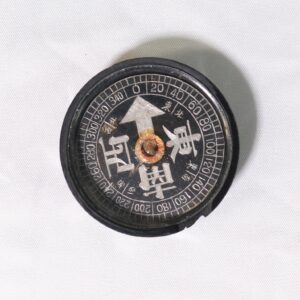 reverse compass, often characterized by having east and west reversed compared to standard compasses.It typically features a black face with Kanji characters indicating cardinal directions, with 
